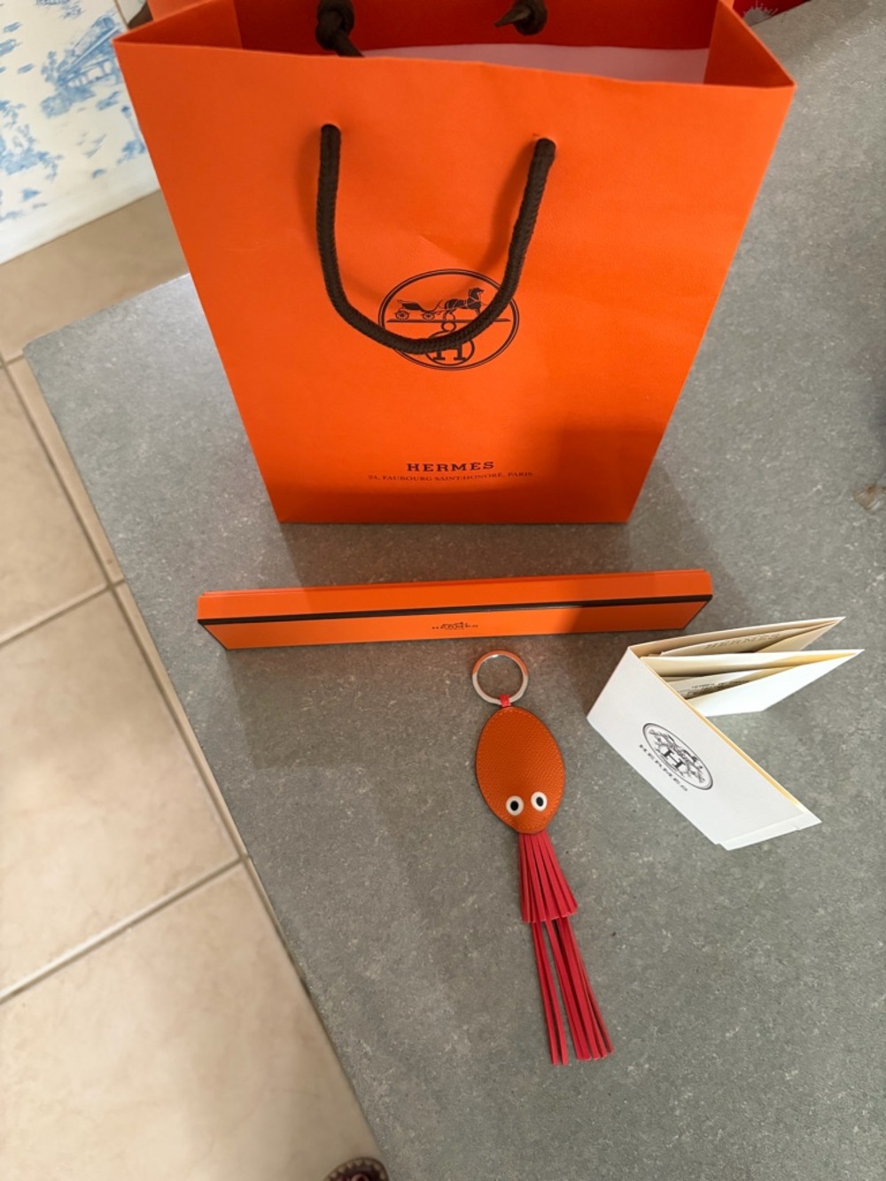 Hermes Orange Leather Keychain with Red Fringe and Playful Eyes